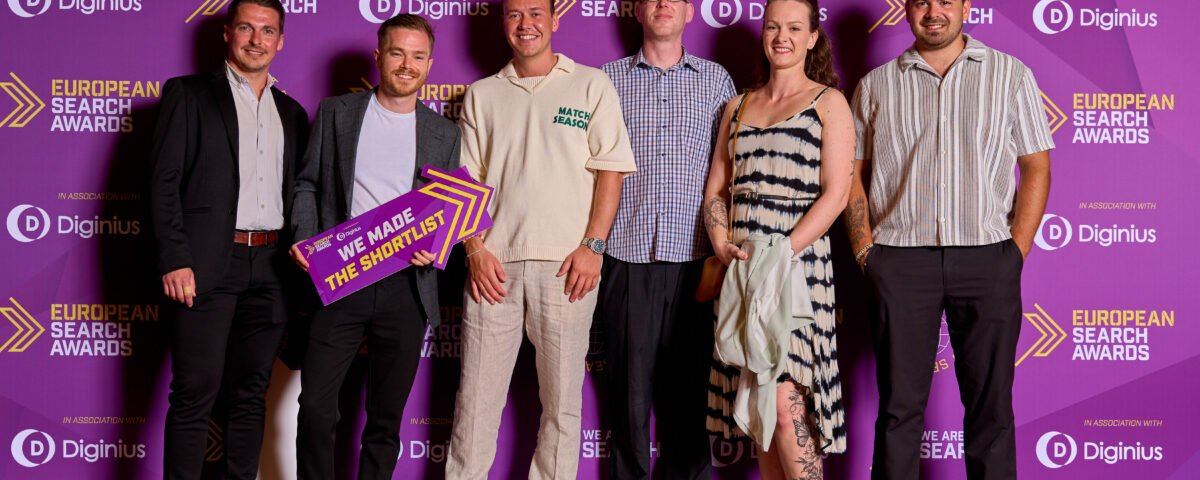 Winners photographed at an awards ceremony backdrop