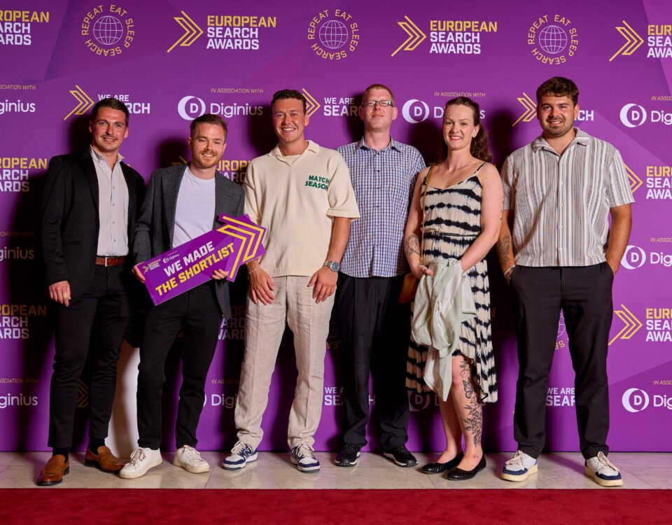 Winners photographed at an awards ceremony backdrop