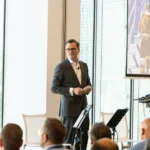 Keynote speaker on stage at a Prague conference venue
