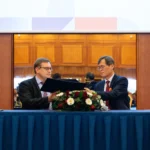 Officials signing an agreement at a diplomatic event in Prague