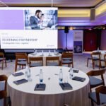 Round-table corporate session with presentation screen in Prague