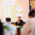 Panel moderator in front of the panel screen at the Allegro Brand Day in Prague