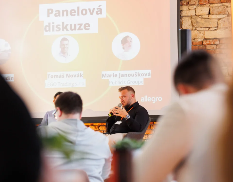 Panel moderator in front of the panel screen at the Allegro Brand Day in Prague
