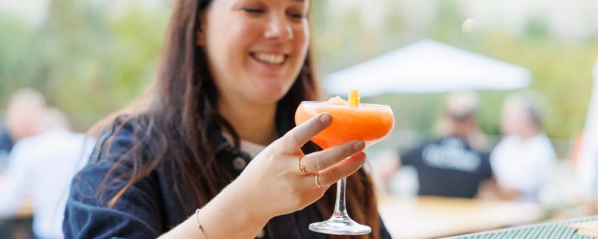 Guest with a cocktail at the outdoor reception at the Allegro Brand Day in Prague