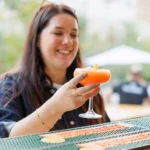Guest with a cocktail at the outdoor reception at the Allegro Brand Day in Prague