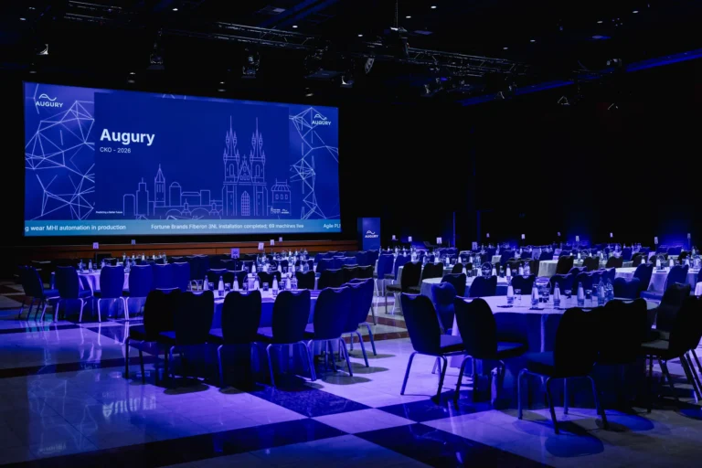 Main hall set with round tables and a stage for a company kick-off at Hilton Prague Atrium