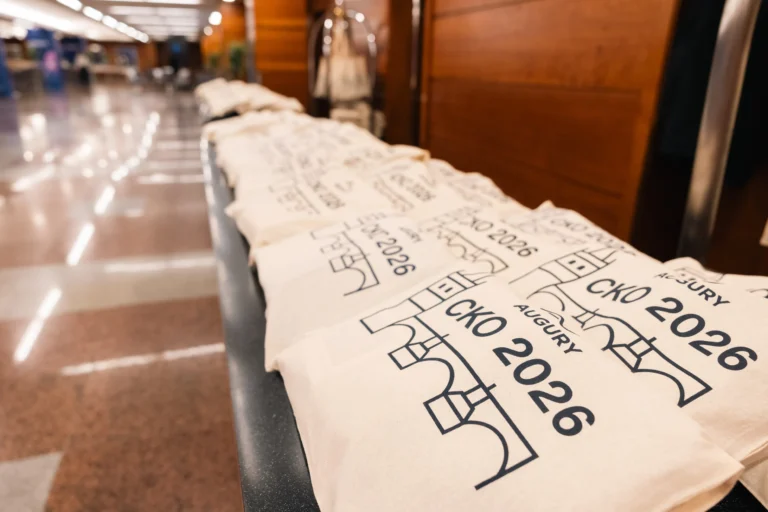 Branded tote bags lined up for attendees at Hilton Prague Atrium