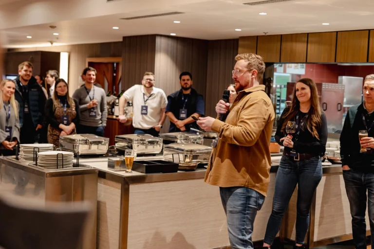 Speaker addressing attendees at a buffet reception at Hilton Prague Atrium