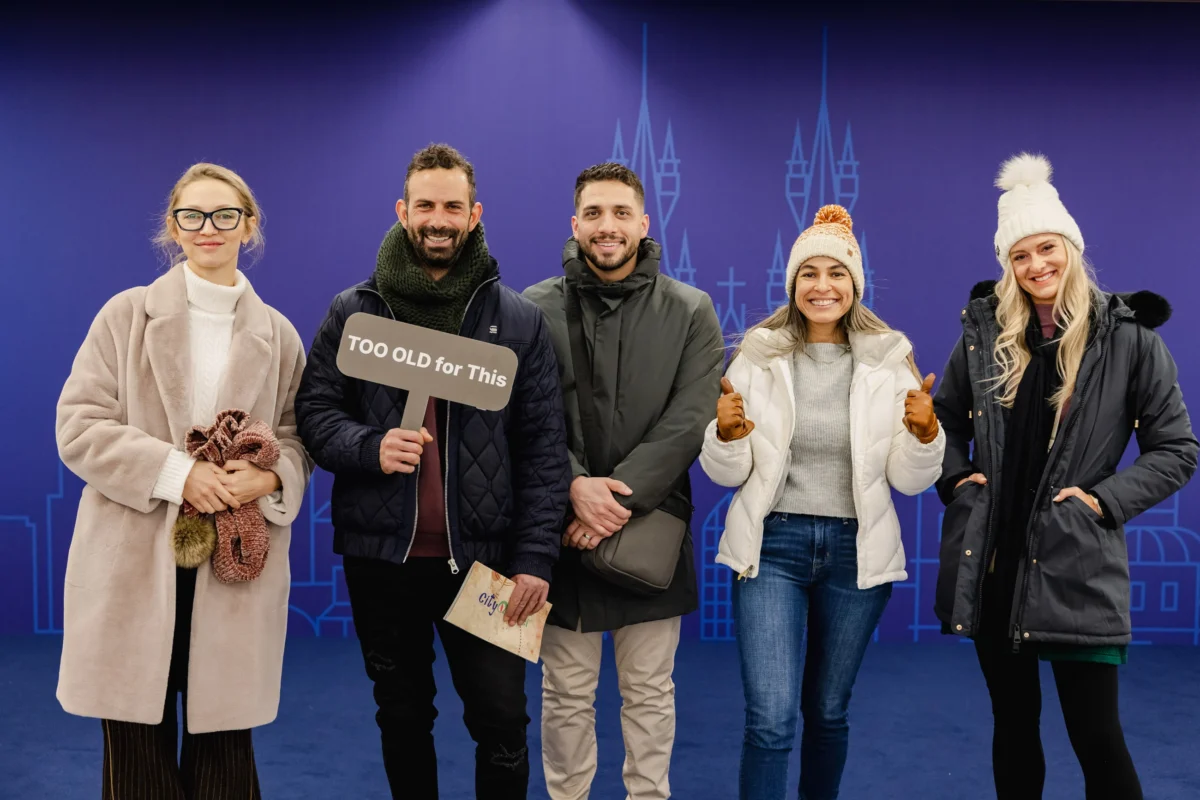 Attendees posing at a branded photo wall during a company kick-off in Prague